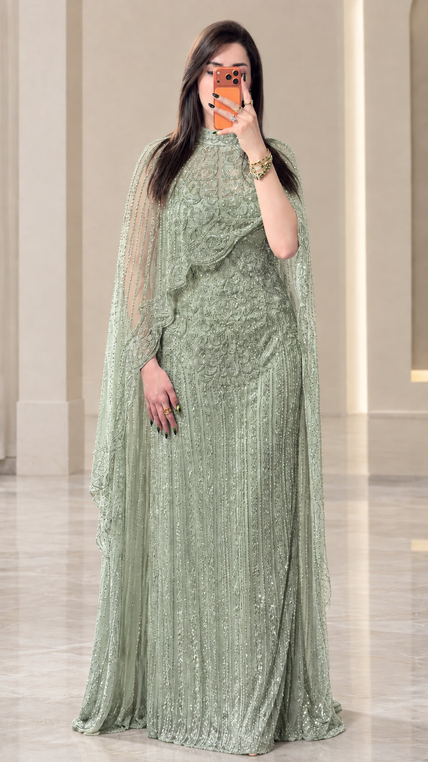 Full-length view of sage green beaded floor-length cape gown