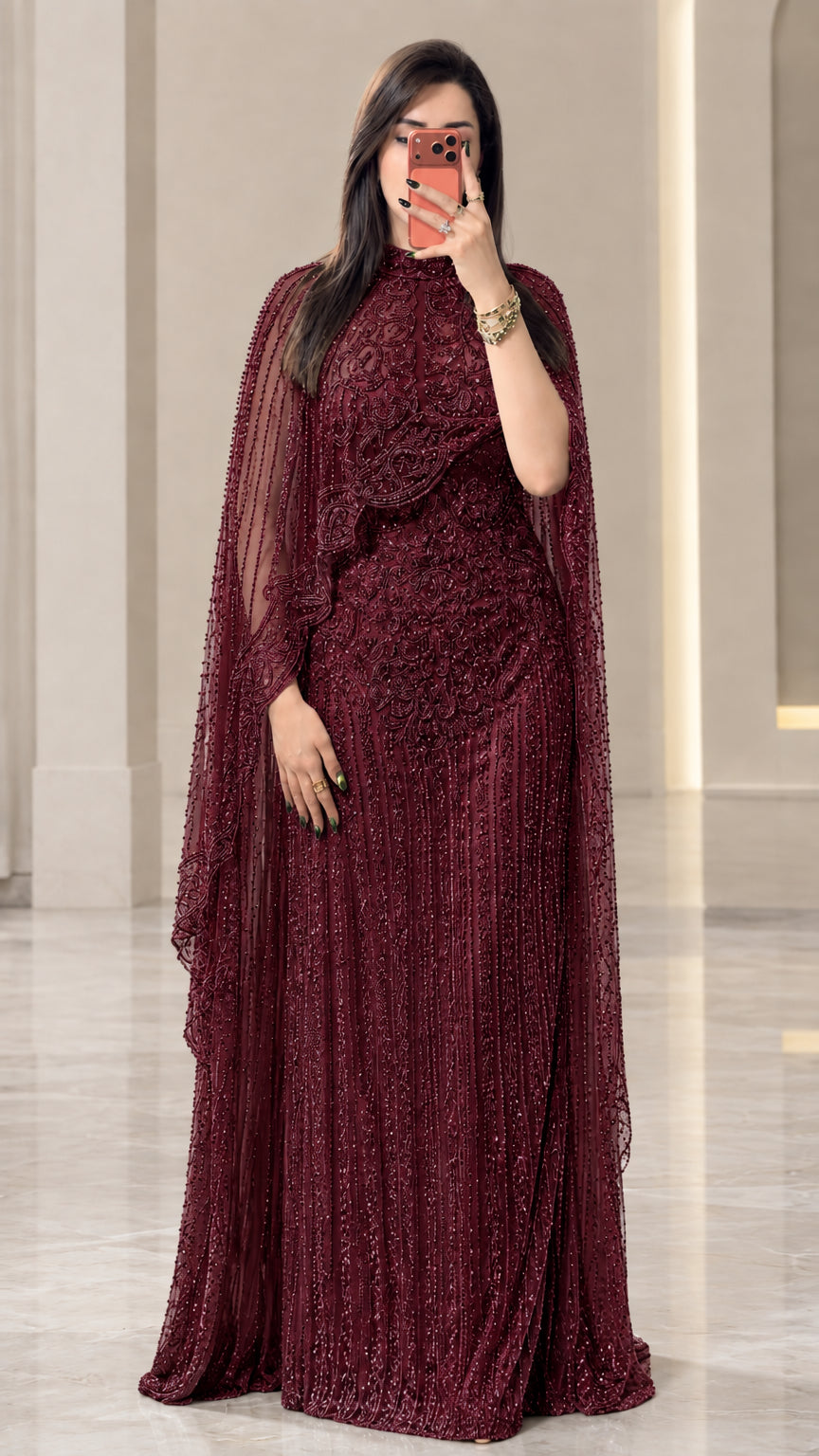 Full-length view of burgundy red embellished cape formal evening dress