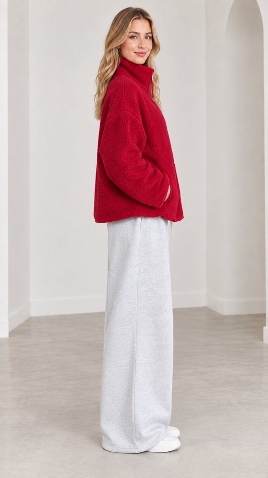 Side view of model wearing red plush fleece jacket with stand collar