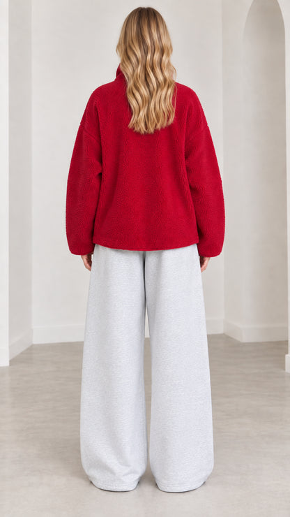 Back view of model in red cozy fleece zip jacket