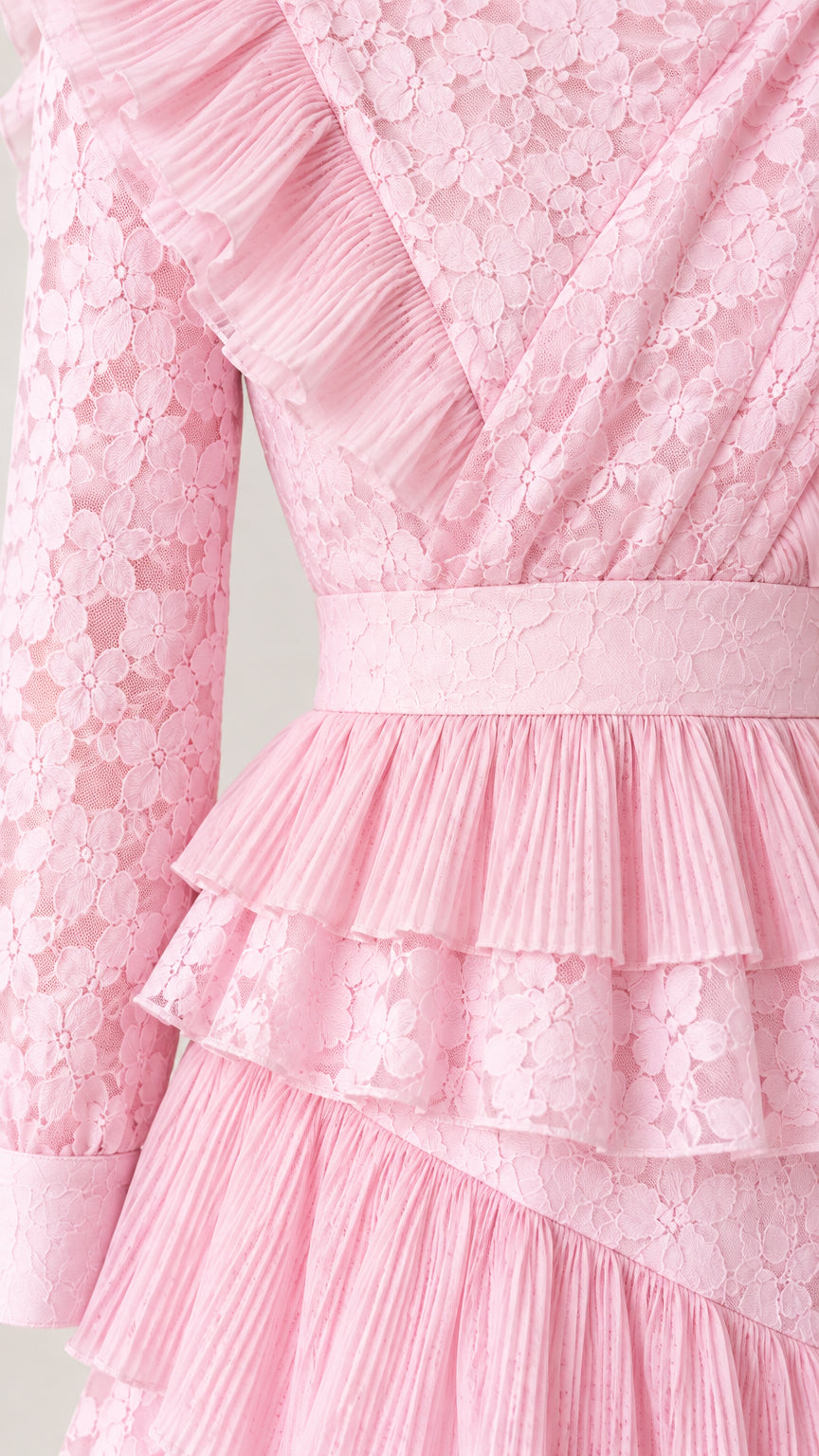 Close up of bodice ruffles and pleated waist details on pastel pink lace dress