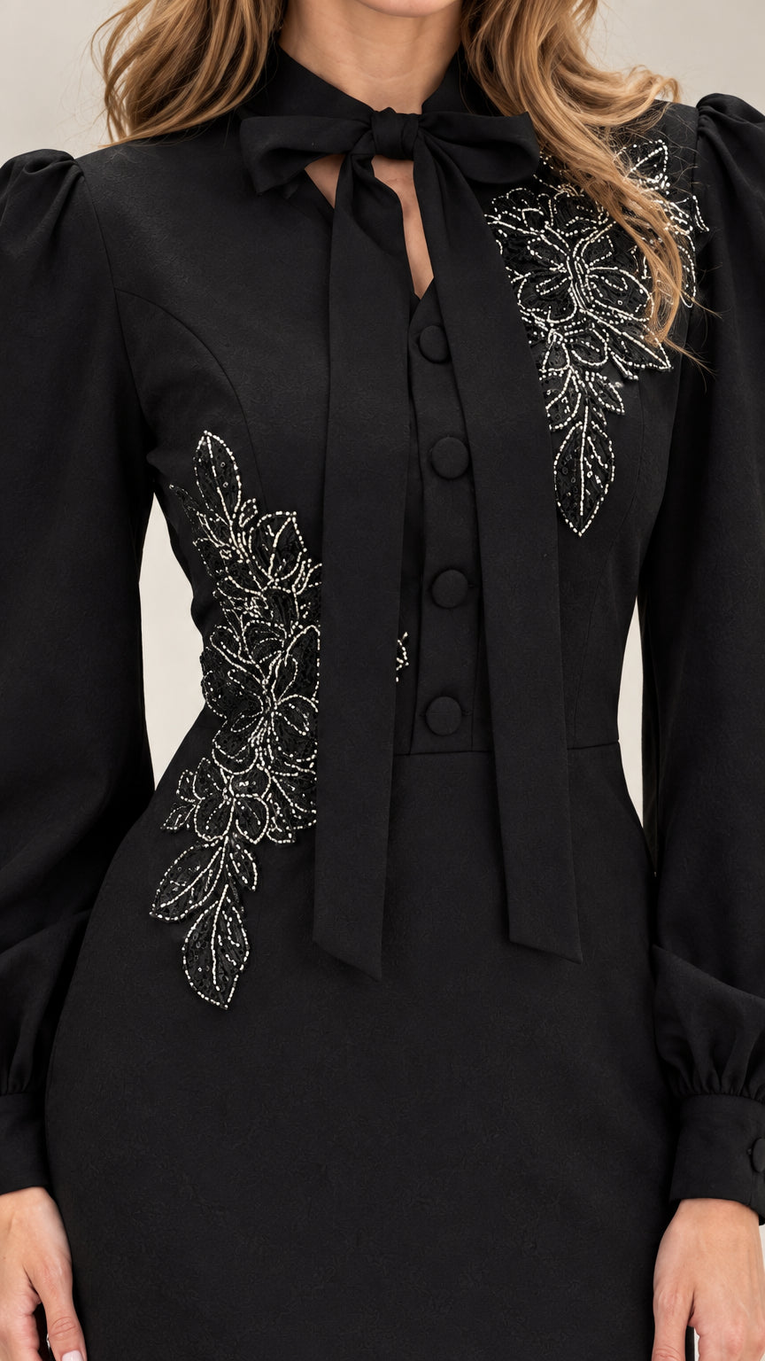 Close-up of bow collar and sparkling floral embroidery on black dress