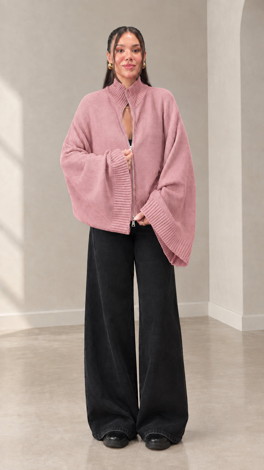 Woman wearing dusty pink zip-front flared sleeve knit sweater