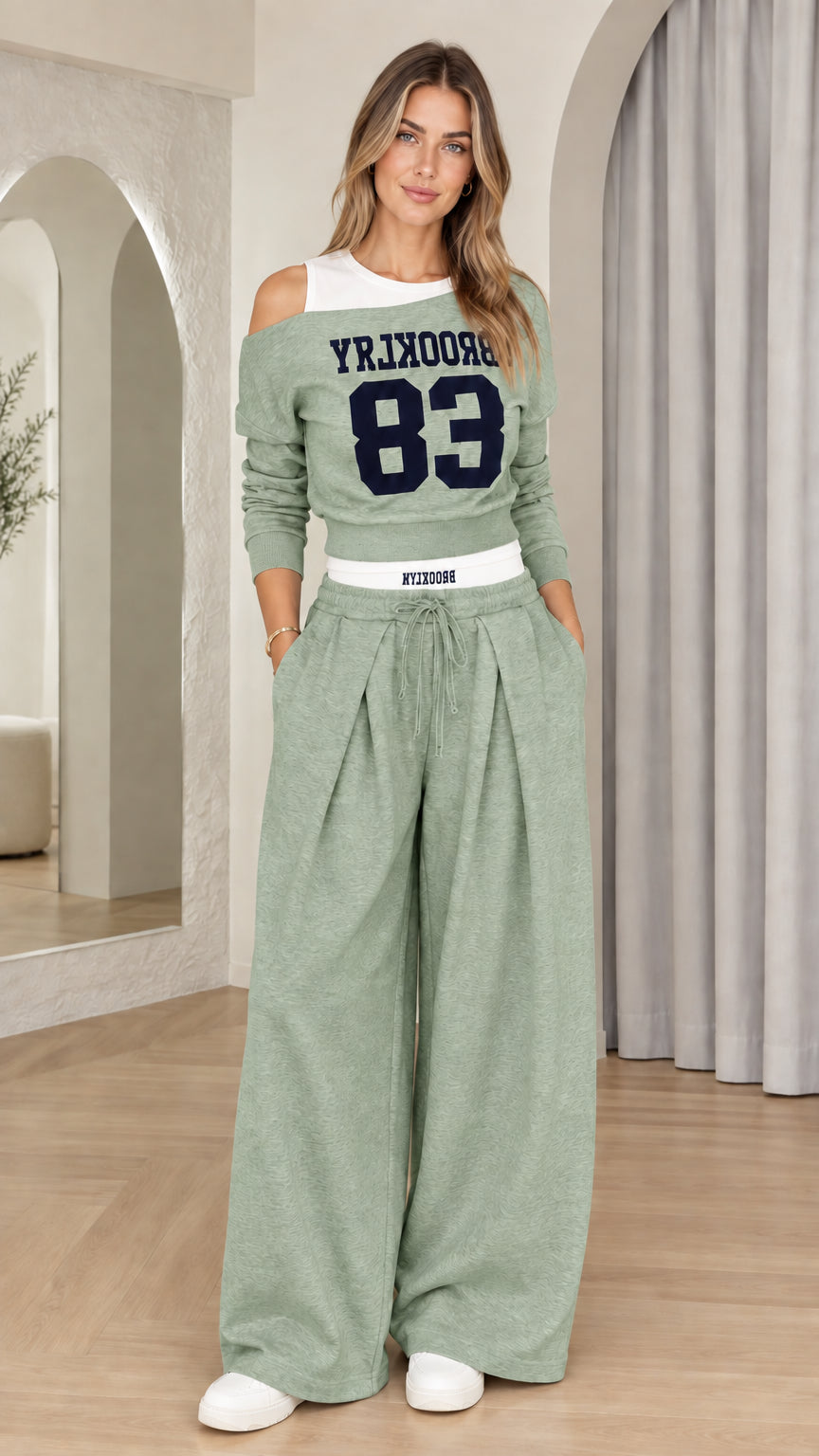 Front view of woman wearing Sage Green Brooklyn 83 cutout sweatshirt and matching pants set