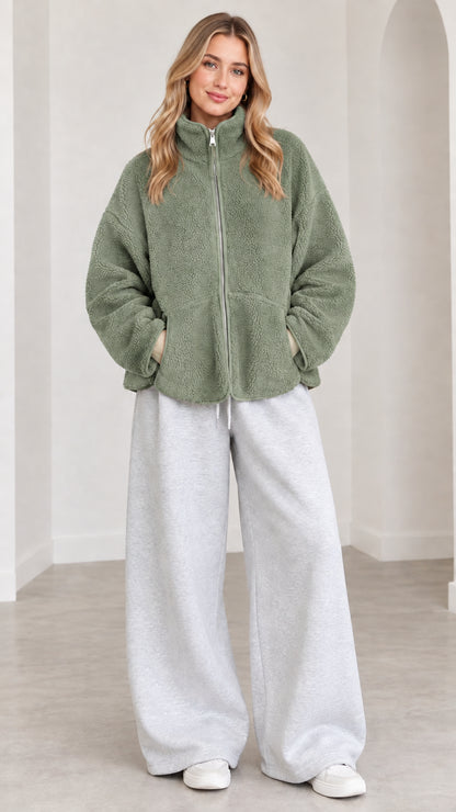 Model wearing sage green fleece zip-up jacket