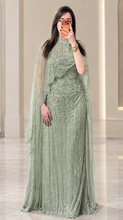 Full-length view of sage green beaded floor-length cape gown