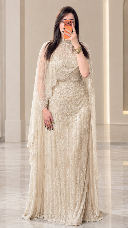 Full-length view of champagne gold sequined cape evening maxi dress